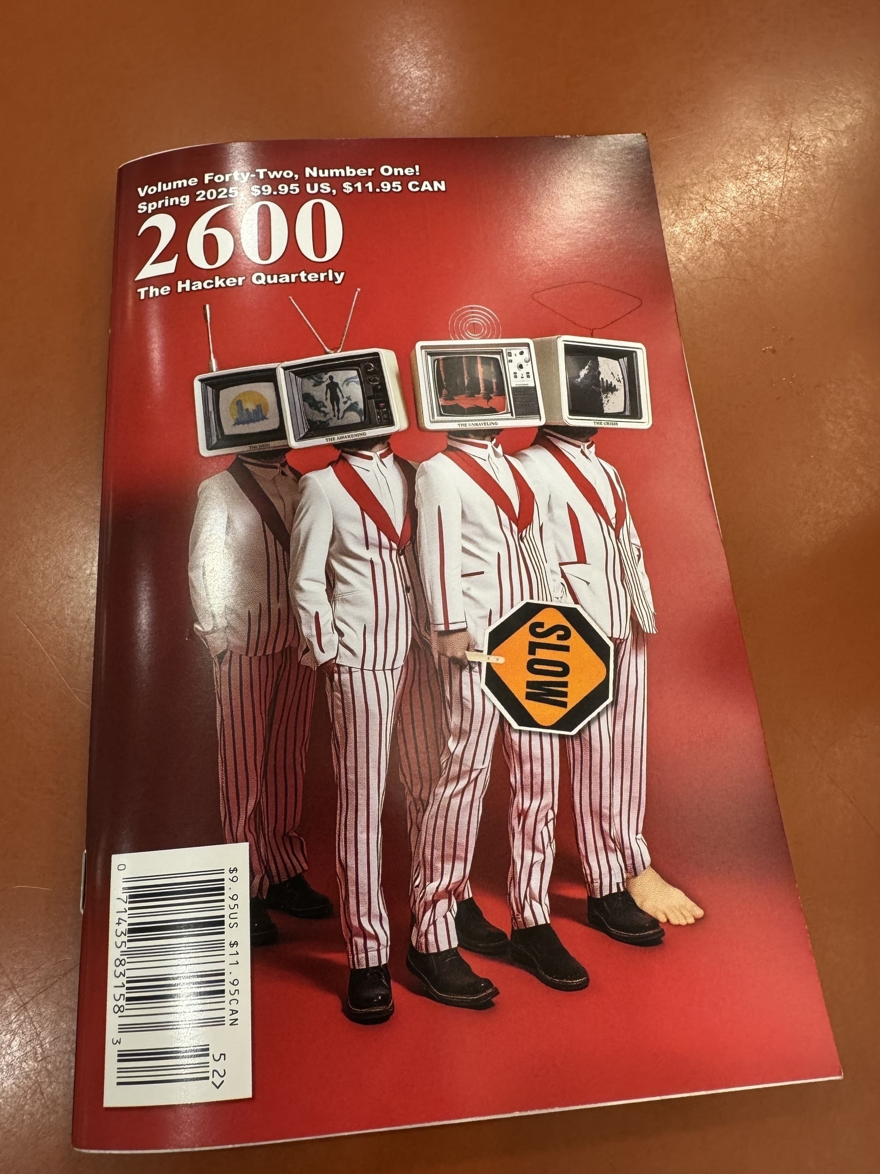 Four figures in red and white striped suits have vintage televisions for heads on the cover of a magazine titled "2600 The Hacker Quarterly."